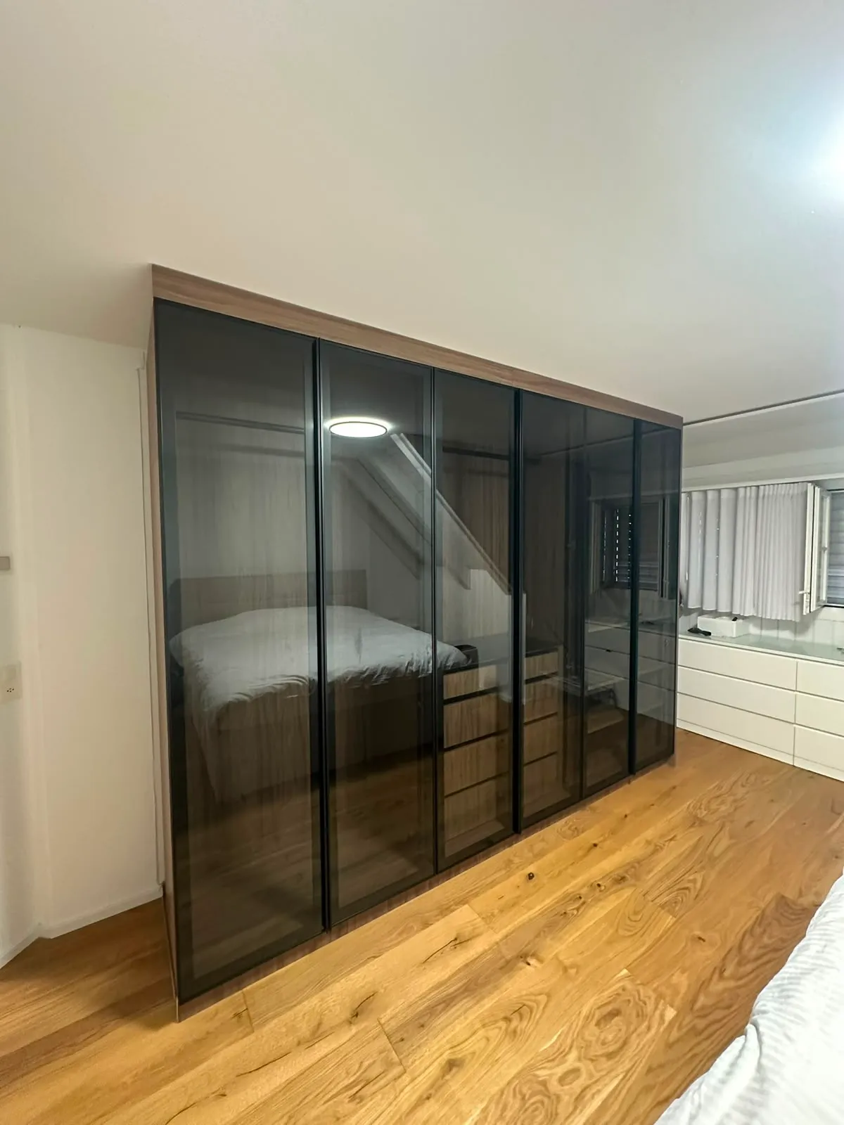 Schrankwand mit getönten Glasfronten im Schlafzimmer